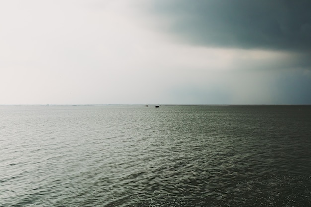 Kleine hut in het midden van de zee onder komende storm