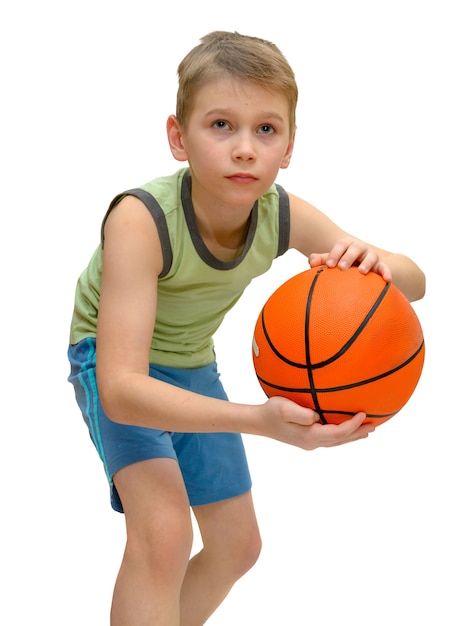 Kleine jongen 9 jaar oud met basketbal geïsoleerd. Kind bereidt zich voor om de bal te gooien