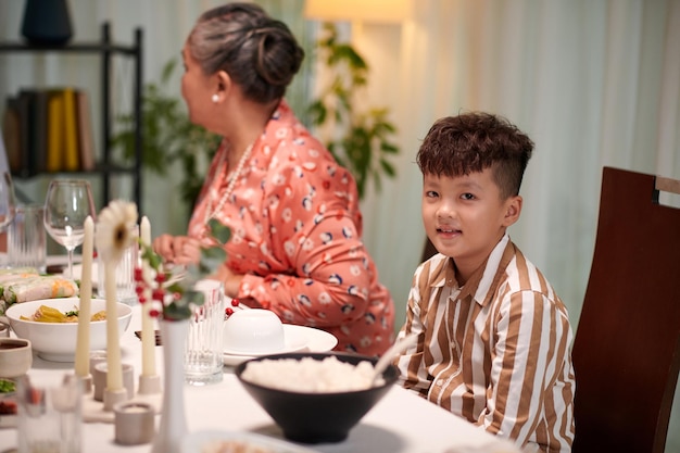 Kleine jongen aan de eettafel.
