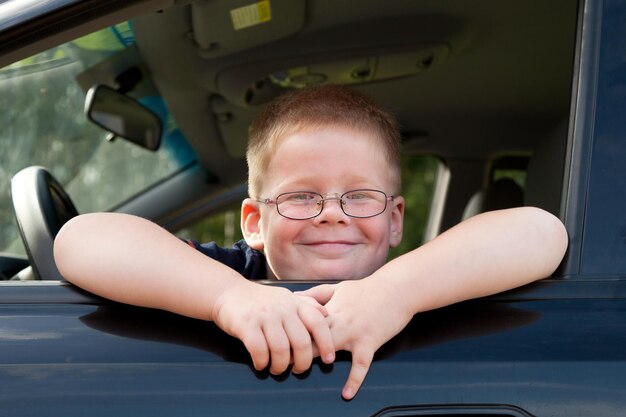 Kleine jongen automobilist achter het stuur