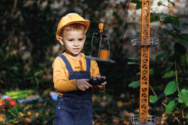 Kleine jongen bouwer in uniform werken op bouwplaats kind toekomstige ingenieur bouwer architect