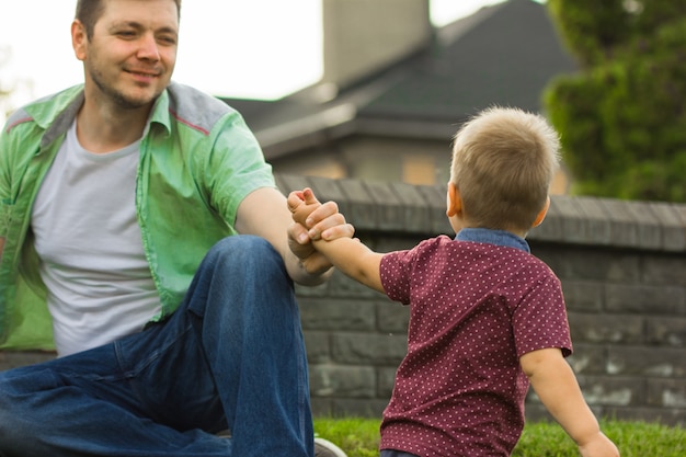 Kleine jongen die de hand van zijn vader. concept van vaderdag! gelukkig gezin vader en kind