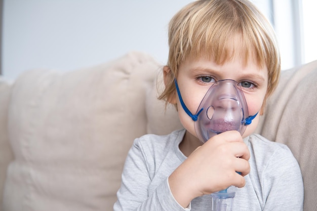 Foto kleine jongen die een stoominhalator nebulizer gebruikt gezondheidszorg