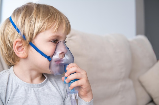 Foto kleine jongen die een stoominhalator nebulizer gebruikt gezondheidszorg