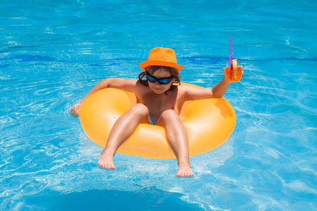 Kleine jongen die in een zwembad drijft op zomervakantie, kind dat in het zwembad drijft, kind dat ontspant in