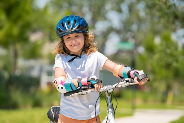 Kleine jongen die op een fiets rijdt in het zomerpark, kinderen die leren fietsen op een oprit buiten