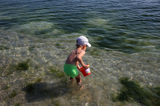 Kleine jongen die op het zeestrand speelt