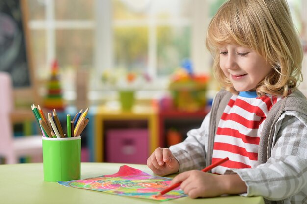 Kleine jongen die thuis lessen geeft in zijn kamer