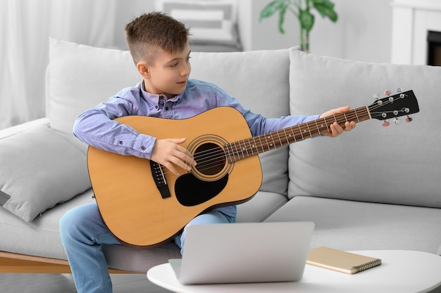 Kleine jongen die thuis muzieklessen neemt