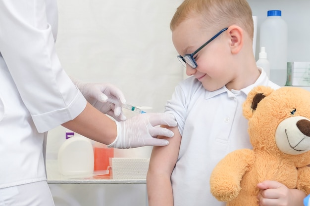 Kleine jongen die vaccinatie krijgt in de kliniek, close-up. Viruspreventie