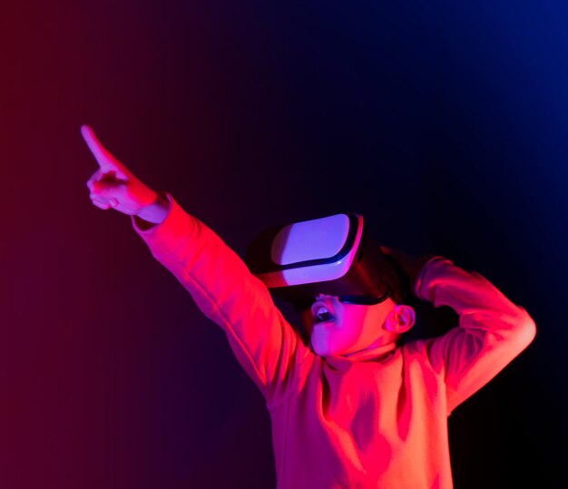 kleine jongen die verrast naar voren kijkt terwijl hij een virtual reality-bril gebruikt