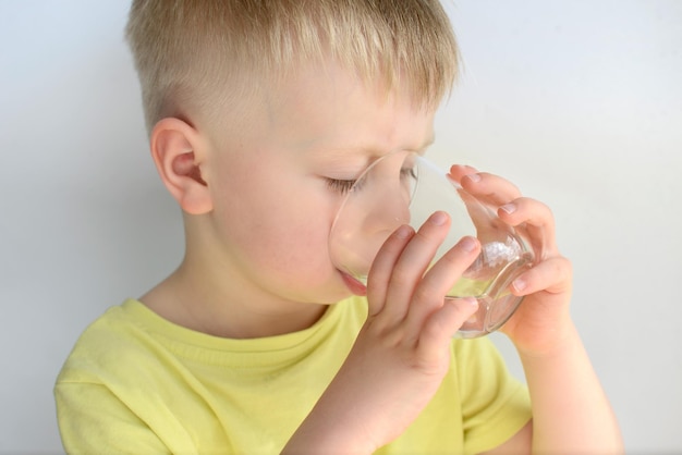 kleine jongen drinkt water uit een glas