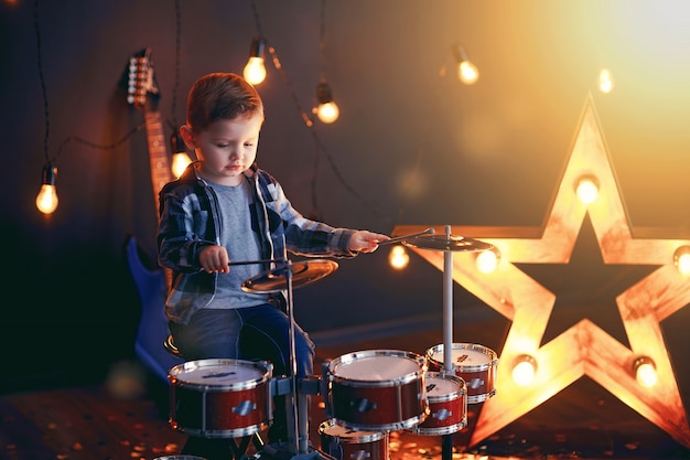 Kleine jongen drummen op het podium