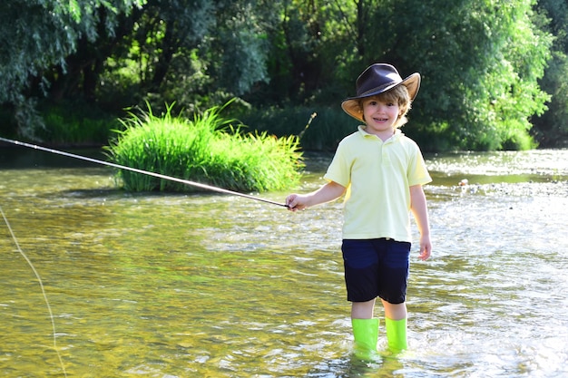 Kleine jongen een vis vangen Kinderen vissen Jongen vissen in de vijver Kleine jongen visser met hengel