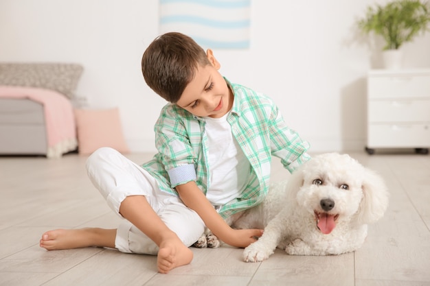 Kleine jongen en bichon frise hond thuis