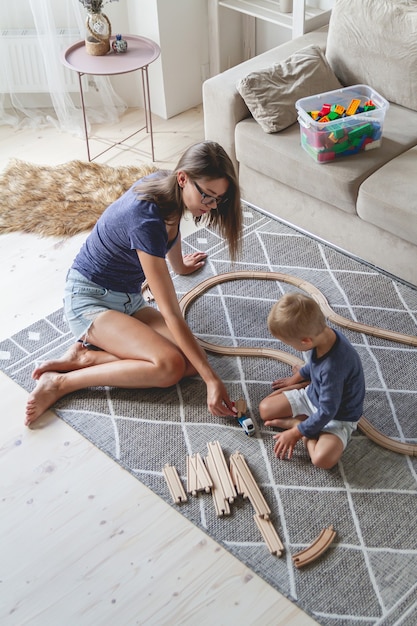 Kleine jongen en zijn moeder spelen met spoorweg