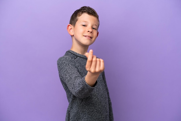 Kleine jongen geïsoleerd op paarse achtergrond geld gebaar maken