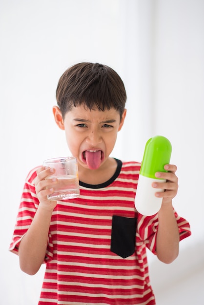 Kleine jongen geneeskunde medicijn te nemen