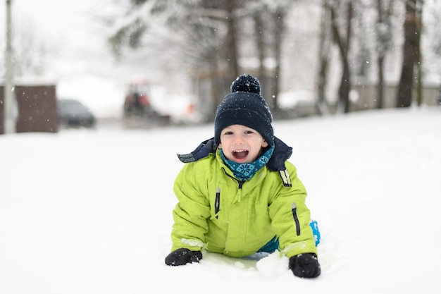 Kleine jongen heeft plezier in de sneeuw