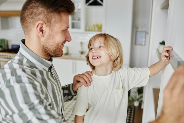 Kleine jongen helpt vader met huisverbetering