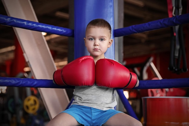 Kleine jongen in bokshandschoenen op ring