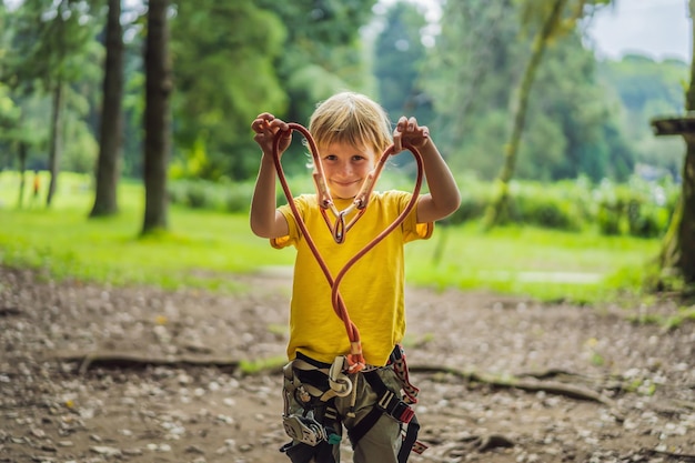 Kleine jongen in een touwpark Actieve fysieke recreatie van het kind in de frisse lucht in het park Training voor kinderen