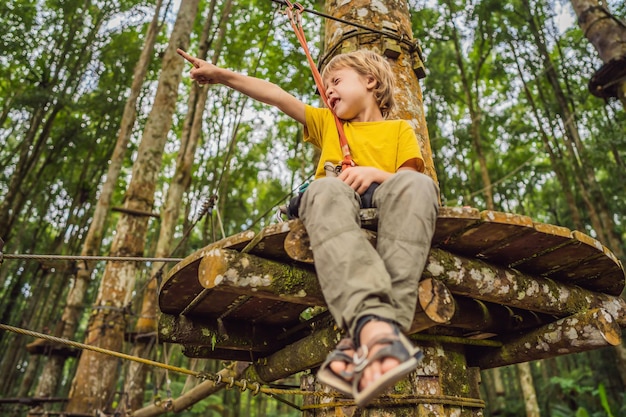 Kleine jongen in een touwpark actieve fysieke recreatie van het kind in de frisse lucht in het park training voor kinderen