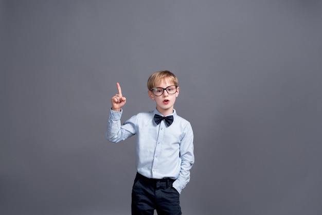 Foto kleine jongen in glazen die zich voordeed op grijs