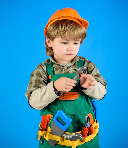 Kleine jongen in helm en gereedschap bouwer kleine reparateur kind spel kind als bouwvakker weinig