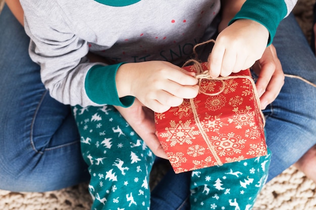 Kleine jongen in pyjama's openen van een geschenkdoos