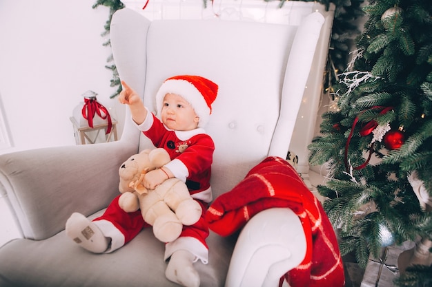 Kleine jongen in Santa Claus-kostuum in licht interieur