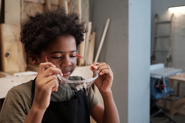 Kleine jongen in werkplaats