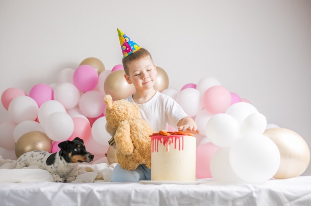 Kleine jongen in witte ballonnen met hem hond