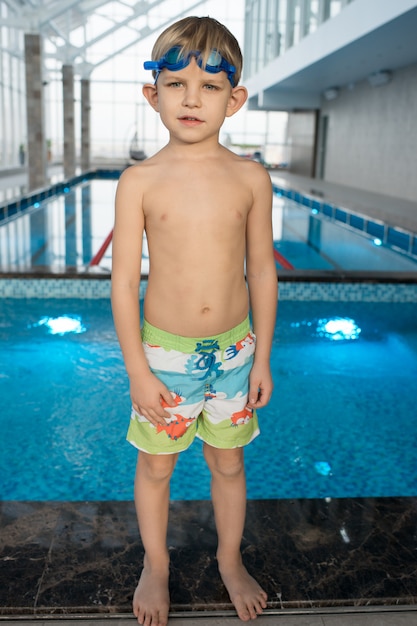 Kleine jongen in zwembroek bij een zwembad