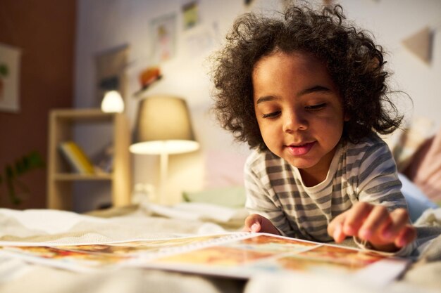 Kleine jongen kijken naar foto's in boek