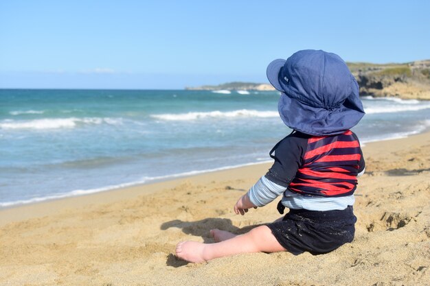 Kleine jongen kijkt naar de oceaan