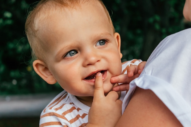 Kleine jongen kijkt over de schouder van zijn moeder