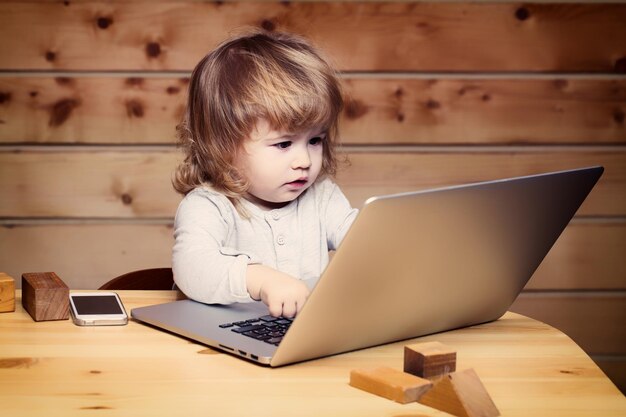 Kleine jongen met computer en telefoon