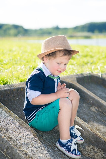 Kleine jongen met een hoed heeft plezier in het park op een zonnige zomerdag