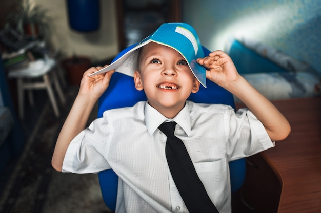 Kleine jongen met een notebook op zijn hoofd