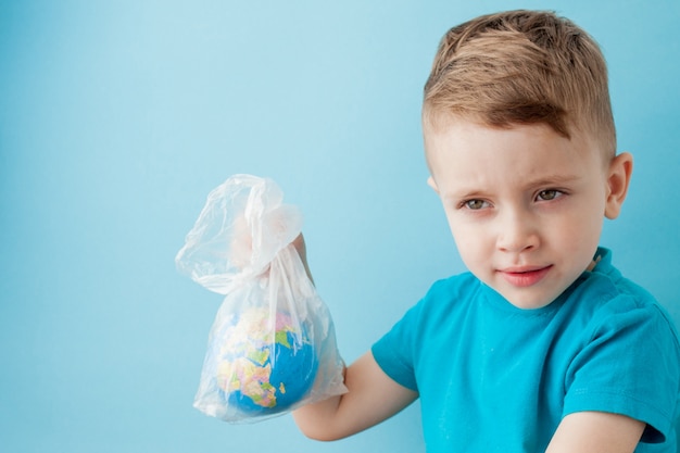 Kleine jongen met een wereldbol in een pakket