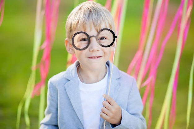 Kleine jongen met grappige papieren bril