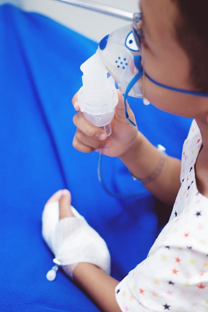 Kleine jongen met inhalator masker in het ziekenhuis