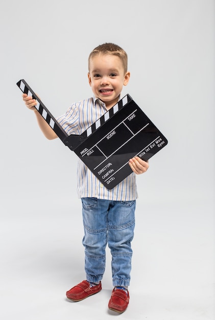 Kleine jongen met klepel bord in de studio