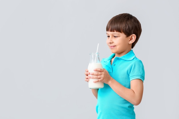 Kleine jongen met melk op licht