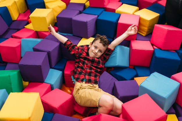 Kleine jongen met plezier met zachte kleurrijke blokjes in kinderentertainmentcentrum. Gelukkige jeugd