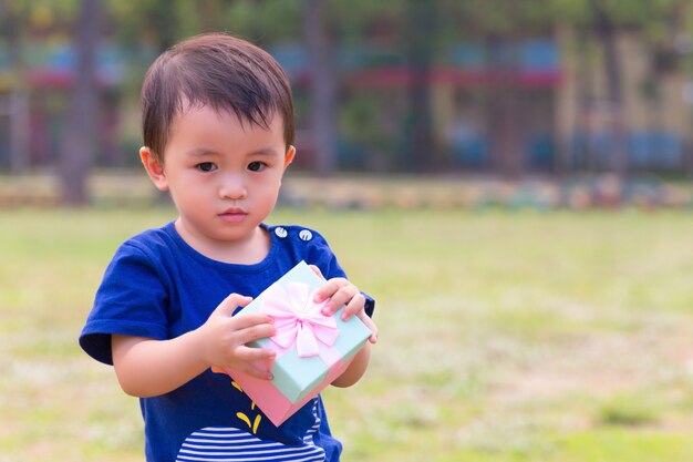 kleine jongen met rode geschenkdoos