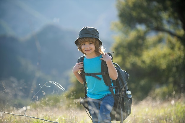 Kleine jongen met rugzak wandelen in schilderachtige bergen jongen lokale toerist gaat op een lokale wandeling