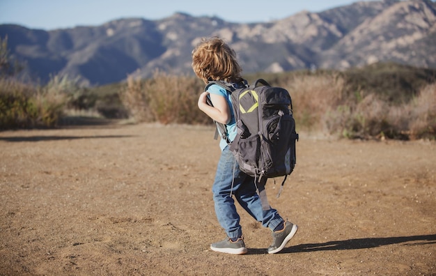 Kleine jongen met rugzak wandelen in schilderachtige bergen kind lokale toerist gaat op een lokale wandeling