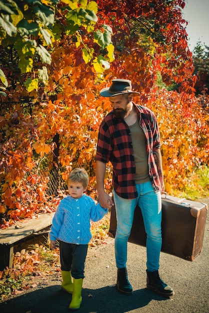 Kleine jongen met zijn vader in de herfst buiten vader en zoon wandelen samen in het park herfstdag